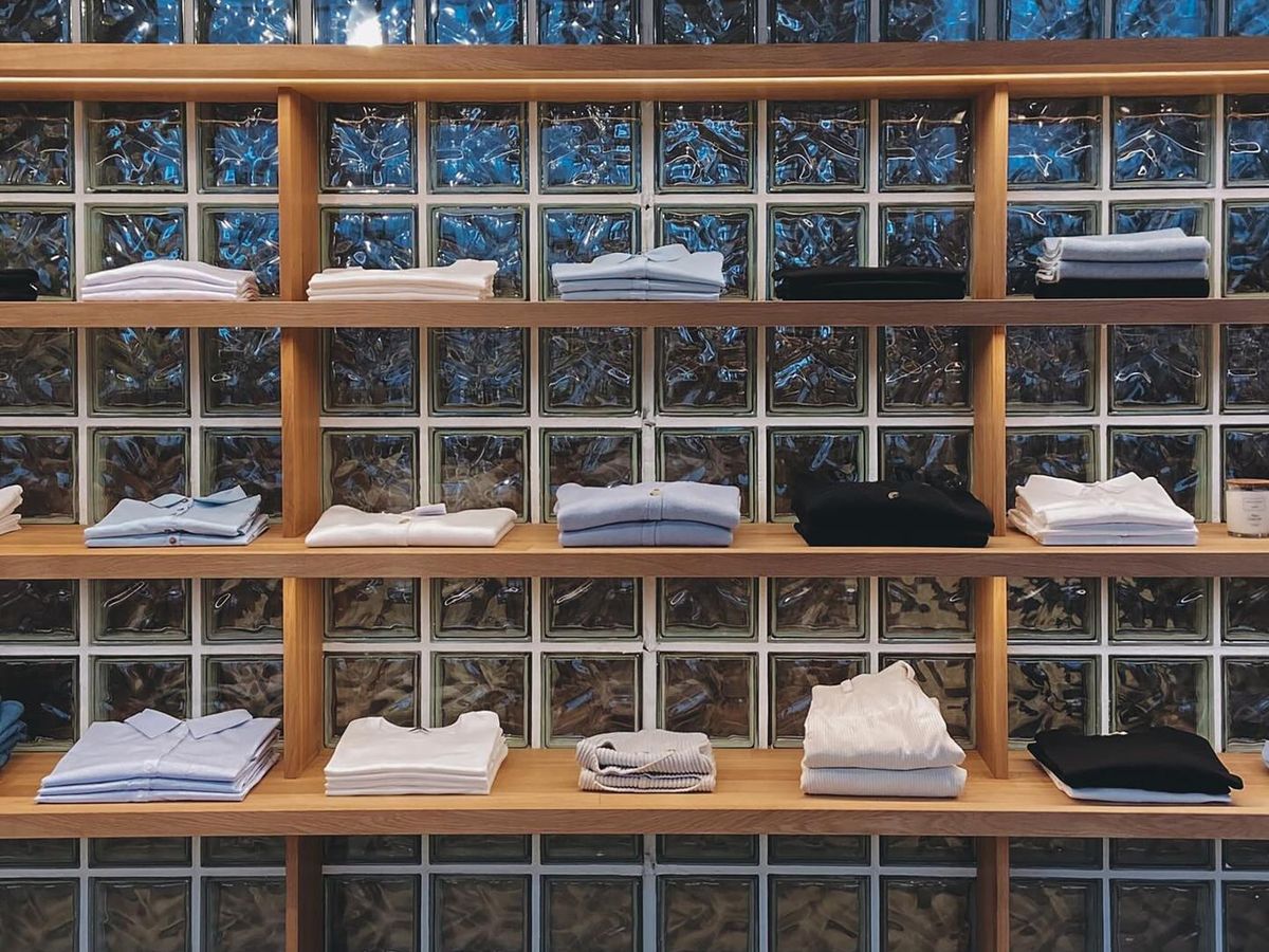 A retail wall of timber pigeonhole shelving, stocked and lit