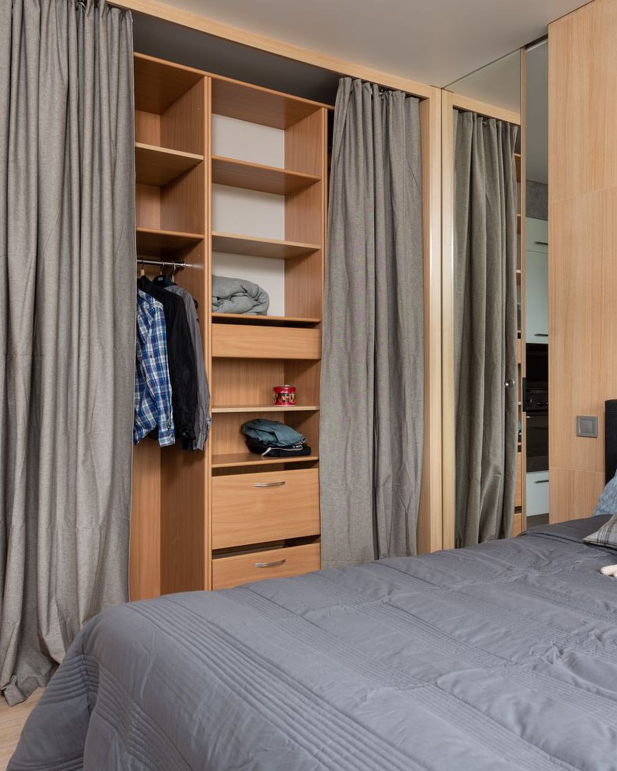 A fitted bedroom wardrobe standing open, showing plywood carcass, shelving and drawer boxes