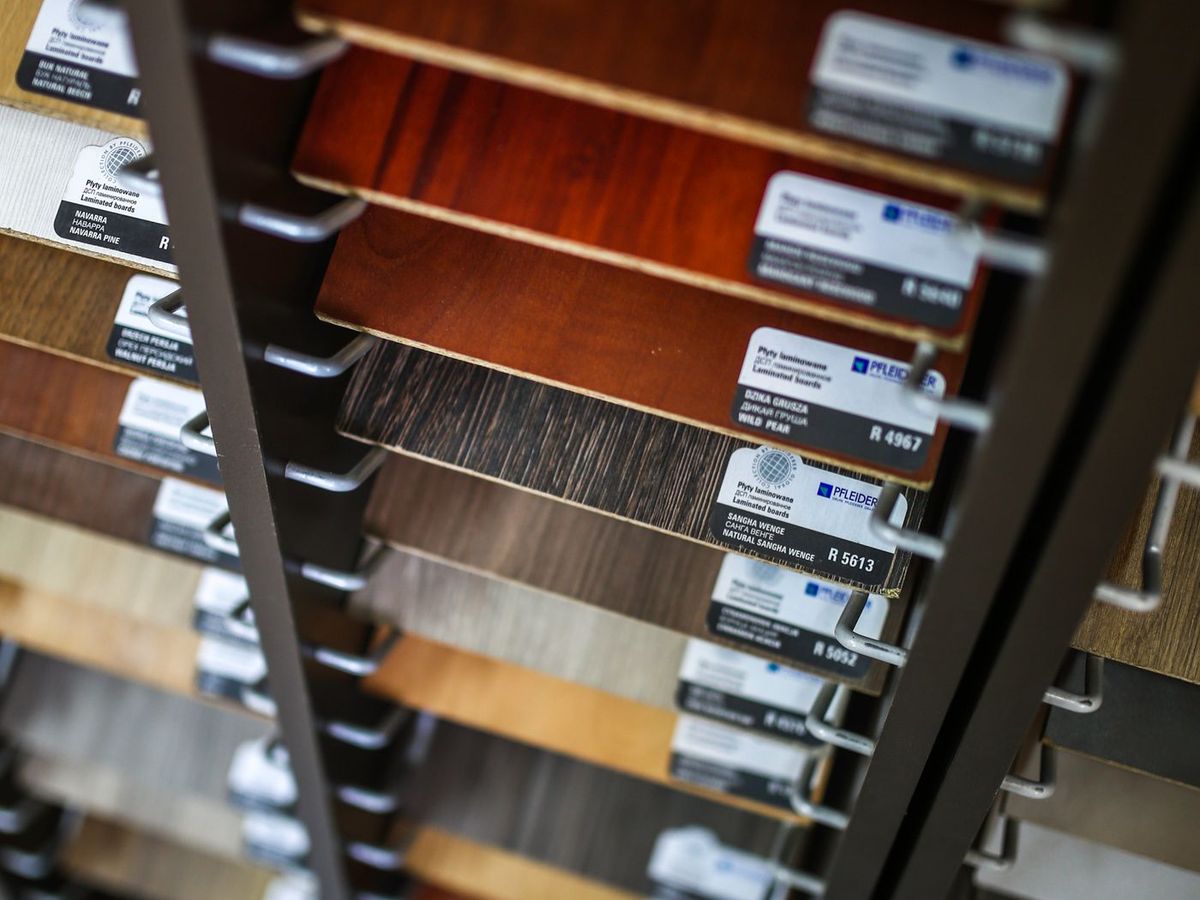 A rack of decorative laminate sample boards in woodgrain and solid finishes