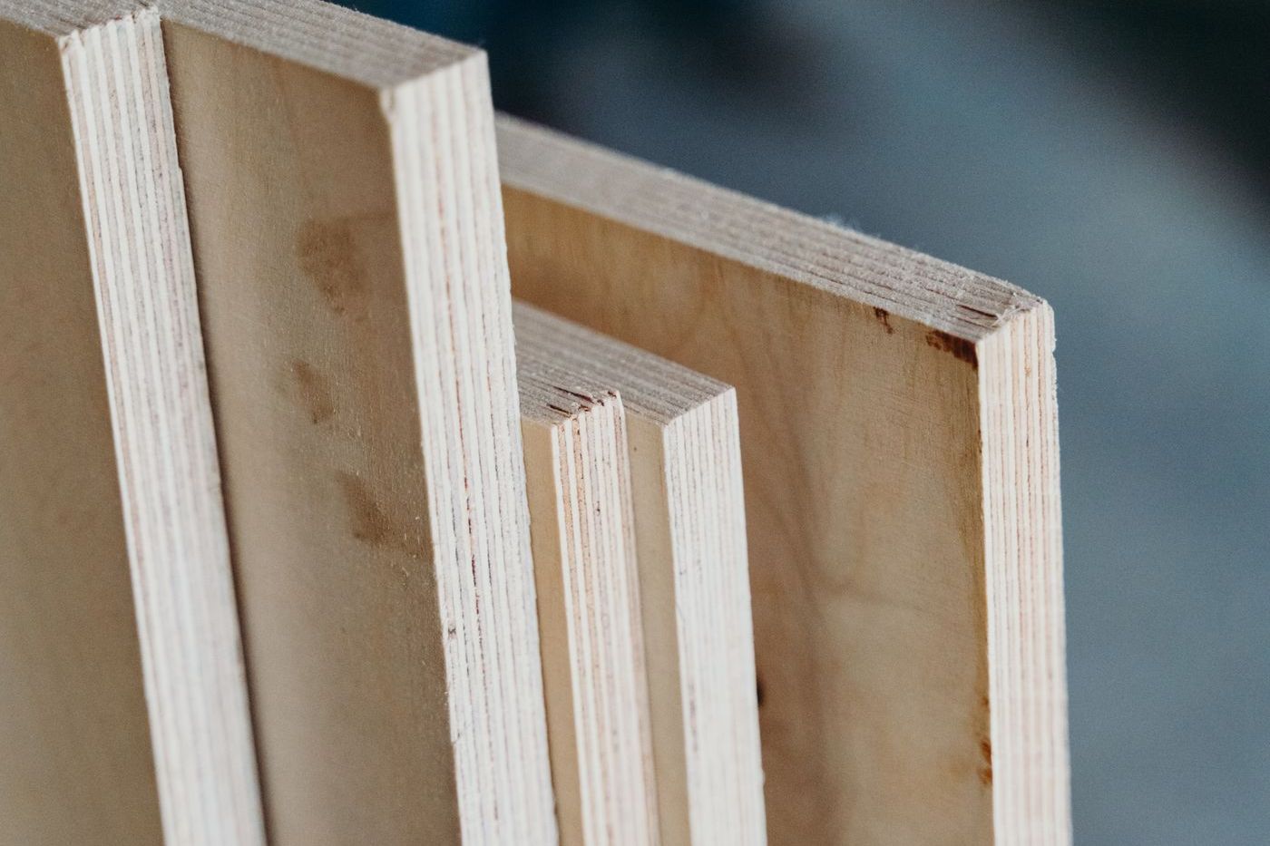 Plywood sheets standing on edge, the veneer plies and glue lines visible in close-up
