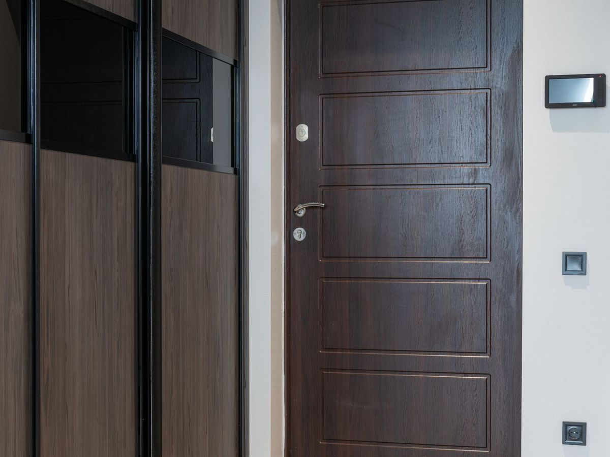 A dark laminated flush door shutter hung in a finished opening